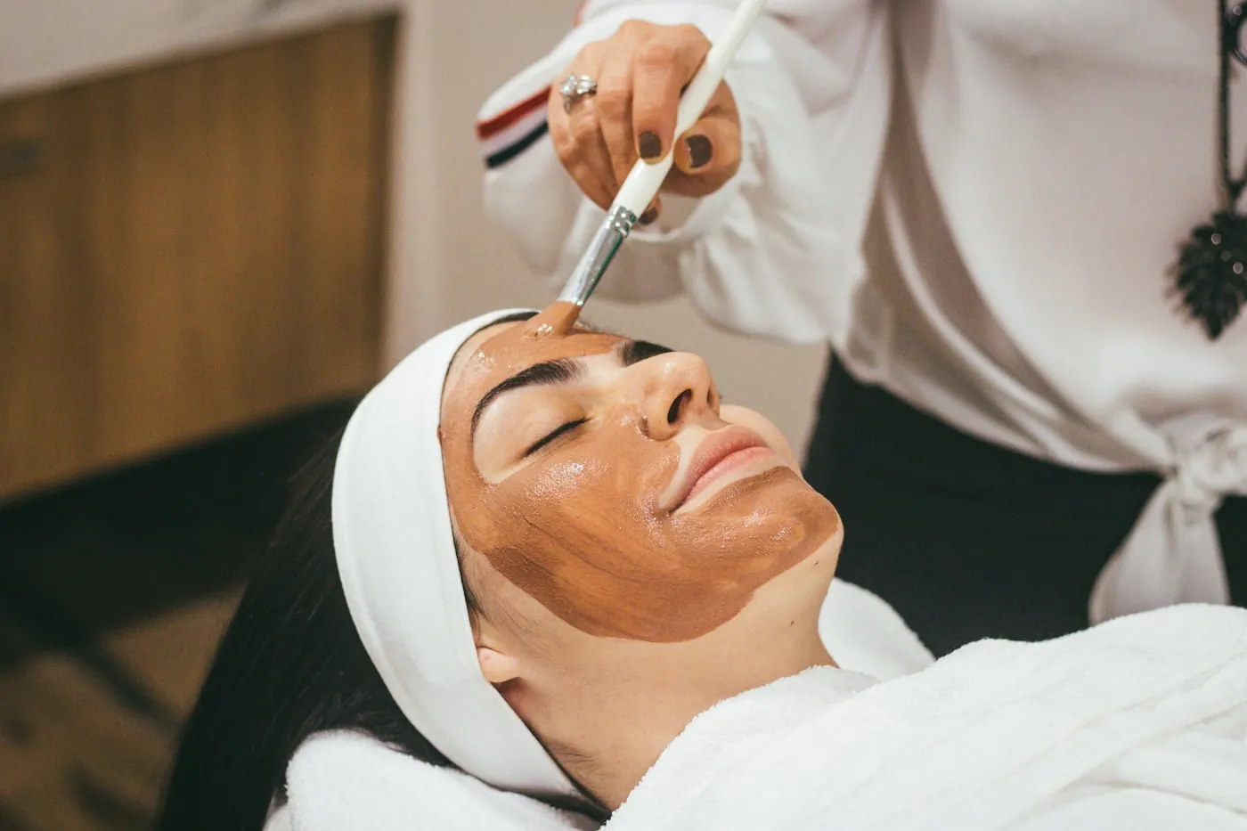 Esthetician analyzing skin during a consultation